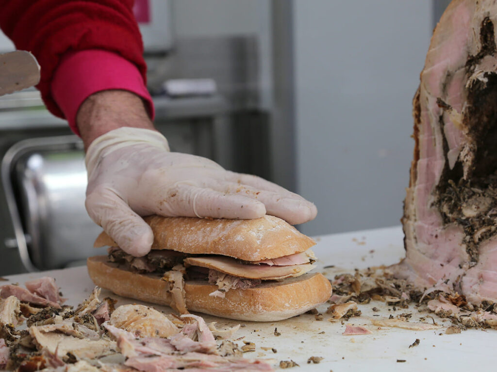 ITS__0003_hand of chef slicing the meat of pork to prepare a sandwich