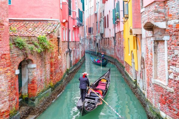 Venetian Gondolier Punting Gondola Through Green Canal — Northern Italy luxury tour by Italy Travel Specialist